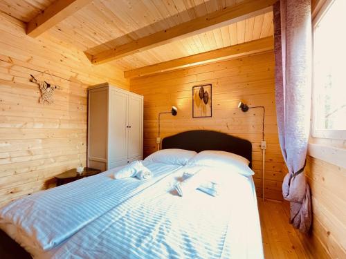 een slaapkamer met een bed in een houten hut bij Inselglück Usedom in Kamminke
