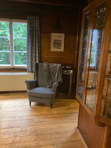 a living room with a chair and a window at Rakouská vila in Bělá pod Pradědem
