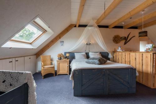 a bedroom with a large bed in a attic at De Notenboom in Meliskerke