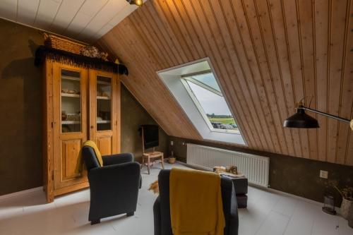 a living room with a vaulted ceiling and a window at De Notenboom in Meliskerke