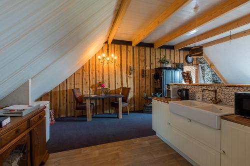 a kitchen with a sink and a table at De Notenboom in Meliskerke