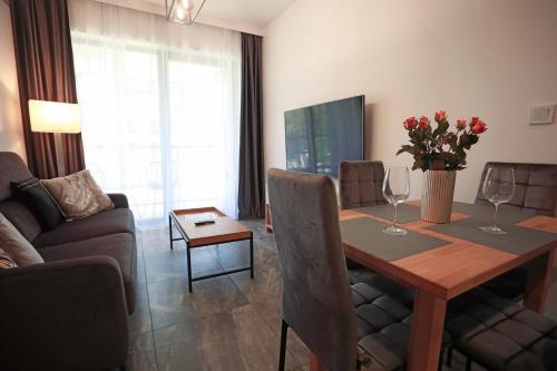 uma sala de estar com uma mesa de jantar com copos de vinho em Shellter Apartament Nadmorski em Rogowo