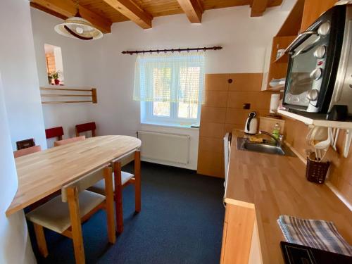 a kitchen with a wooden table and a sink at Chata Maxík in Josefŭv Dŭl