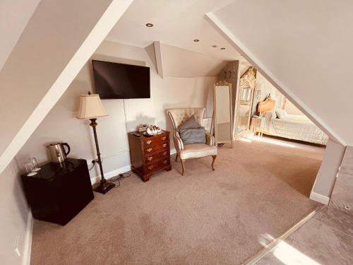 a attic room with a staircase with a chair and a bed at Nuthurst Grange Country House Hotel & Restaurant in Solihull