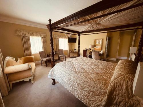 a bedroom with a large bed and a chair at Nuthurst Grange Country House Hotel & Restaurant in Solihull