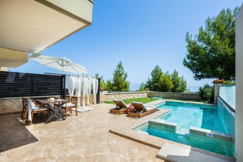 a patio with a pool and a table and chairs at SPA Villa - Sunny Villas Hanioti in Hanioti