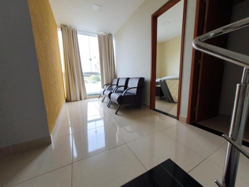 a living room with chairs and a mirror in a room at Casa Duplex Nova em Iriri in Iriri