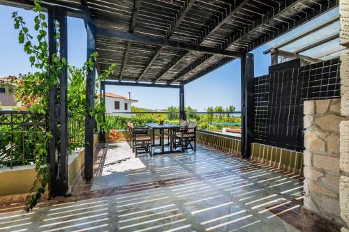 a patio with a table and chairs and a view at SPA Villa - Sunny Villas Hanioti in Hanioti