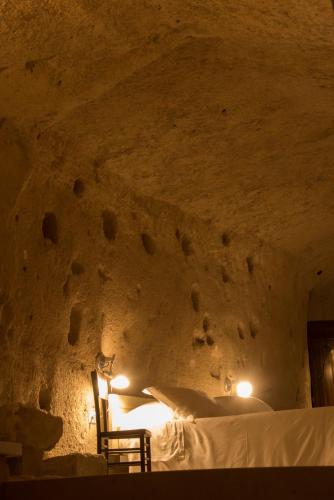 a bedroom with a bed in a stone wall at LA DIMORA DELLE 3 ZIE in Matera