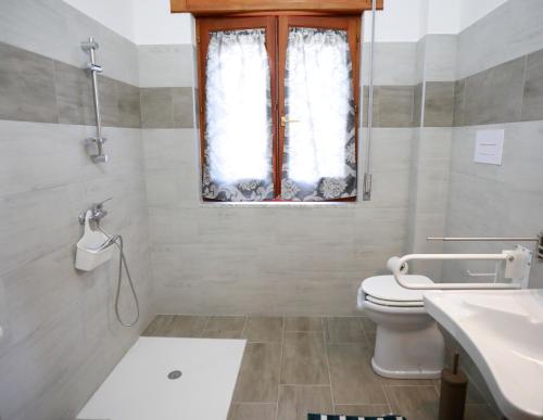 a bathroom with a toilet and a sink and a window at Il Rifugio Delle Stelle in Castelgrande