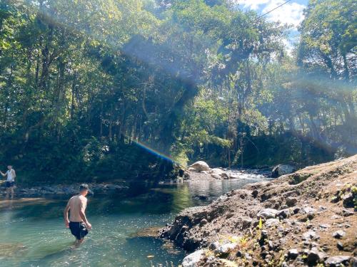 a man standing in the water in a river at Hostal Casa Blanca in El Coca