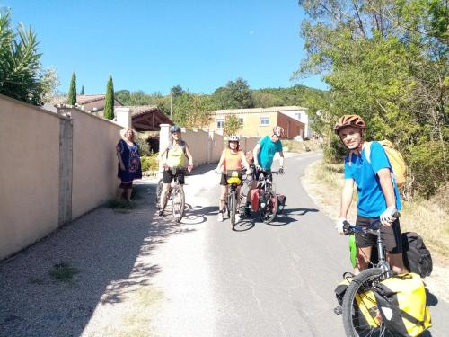 a group of people riding bikes down a road at chambres d'hôtes du capimont in Hérépian