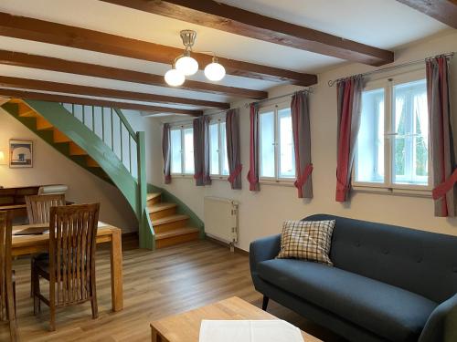 a living room with a blue couch and a staircase at Urlaub im Fachwerk - Klink in Quedlinburg