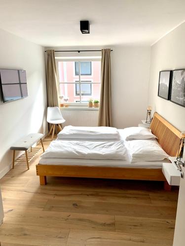 une chambre avec un grand lit et une fenêtre dans l'établissement Haigis Lodge, à Annaberg-Lungötz
