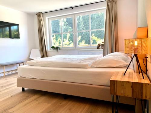 Schlafzimmer mit einem großen Bett und einem Fenster in der Unterkunft Haigis Lodge in Annaberg im Lammertal