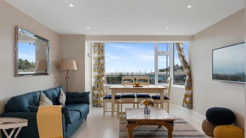 a living room with a blue couch and a table at 1 Dolphin Court, Brixham in Brixham