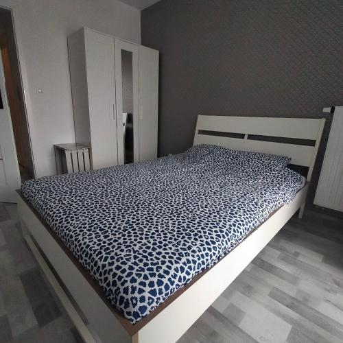 1 dormitorio con 1 cama con edredón blanco y negro en APARTAMENT HELSINKI, en Cracovia