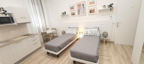 2 posti letto in una camera con cucina e tavolo di SUITE BLANC APARTMENTS - Monolocali indipendenti con cucina e bagno privato - Check-in e check-out con codice in autonomia h24 - Terrazza in comune a Guspini