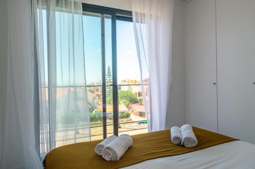 a bedroom with a large window with towels on a bed at Areia da Consolação in Consolacao
