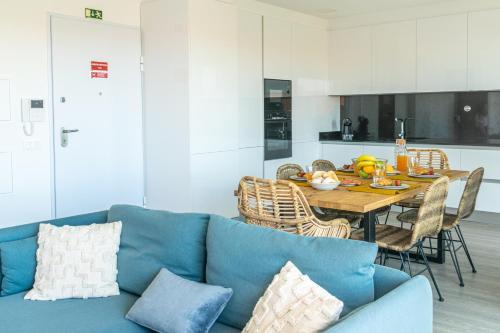 a living room with a blue couch and a table at Areia da Consolação in Consolação