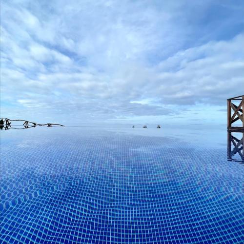una piscina con azulejos azules en el suelo en ModuLAR en Calheta