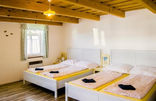 two beds in a room with wooden floors at Chalupa U Čápů in Nové Mlýny