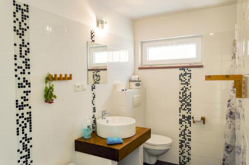 a white bathroom with a sink and a toilet at Chalupa U Čápů in Nové Mlýny