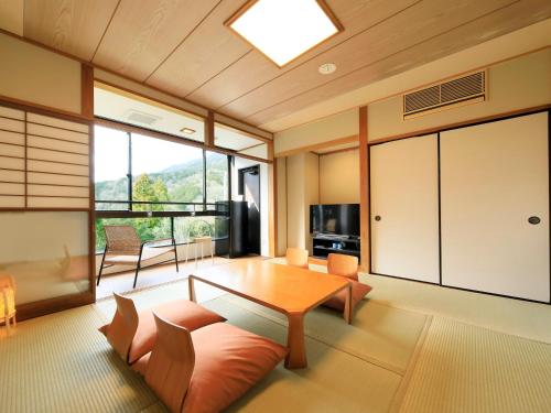 a living room with a table and a large window at Hot Spring Inn Hakone Suisen in Hakone