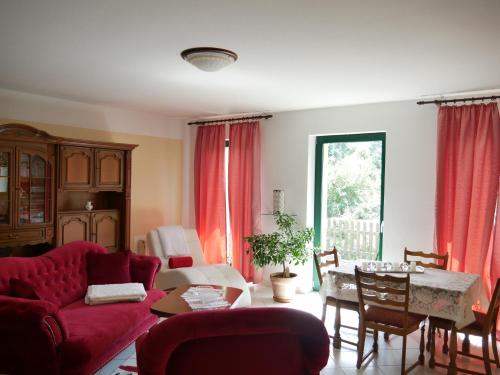 ein Wohnzimmer mit einem roten Sofa und einem Tisch in der Unterkunft Ferienzimmer Weltenbummler,Rheinsberg in Rheinsberg