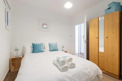 a bedroom with a large white bed with blue pillows at Stylish Soundproof Temple Bar Square in Dublin