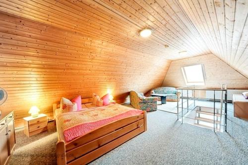 a room with a bed and a wooden wall at Wolf, Barbara, App 2 in Zingst