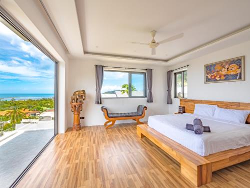 a bedroom with a bed and a view of the ocean at Villas Reef View Garden in Koh Samui