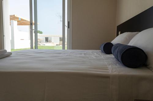 a bedroom with a large bed with two pillows on it at Cantine De Mare - Wine and Resort in Cirò Marina