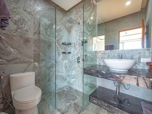 a bathroom with a toilet and a glass shower at Villas Reef View Garden in Koh Samui
