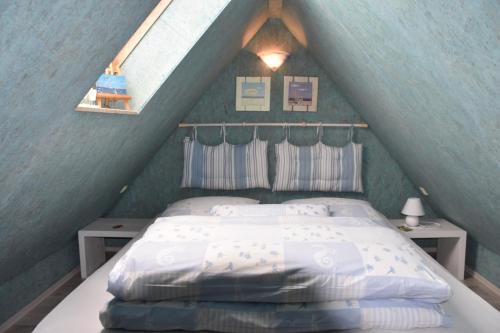 a bedroom with a bed in a attic at "Ostseefische" in Gutglück