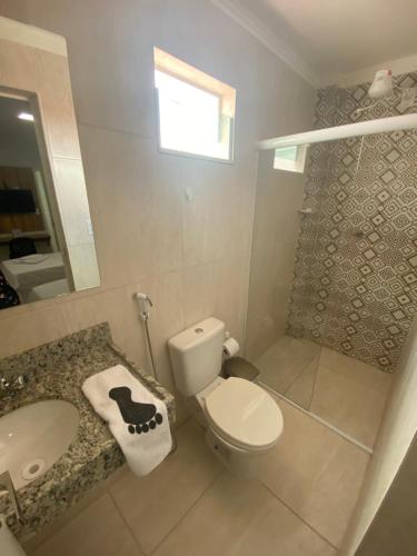 a bathroom with a toilet and a sink and a mirror at Hotel Trevo Caruaru in Caruaru