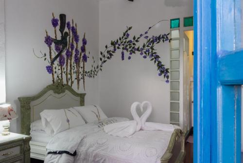 a bedroom with a bed with a flower arrangement on the wall at Hotel Boutique Casa de Hacienda Su Merced in Puembo