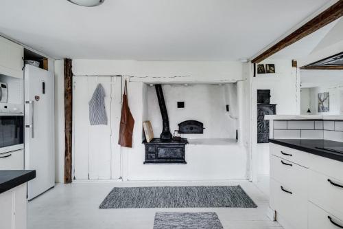uma cozinha com armários brancos e um fogão em Spacious and newly renovated farmhouse with indoor pool em Knäred