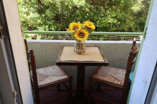 un vase de tournesols sur une table sur une terrasse couverte dans l'établissement Petit Vauban plus, à Saint-Raphaël