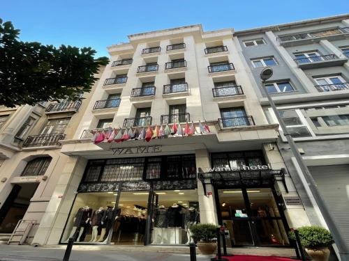 un grand bâtiment blanc avec une façade de magasin dans l'établissement Wame Suite Hotel Nisantasi, à Istanbul