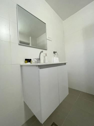 un bagno bianco con lavandino e specchio di על הנחל a Beit She'an