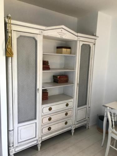 - une commode blanche avec 2 fenêtres dans une pièce dans l'établissement Chambre d'hôte La Clef du Bonheur, à Longuenesse