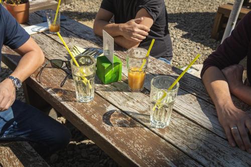 a group of people sitting around a wooden table with drinks at Mátra Sasfészek in Mátraszentimre