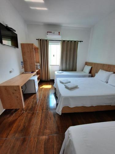 a hotel room with two beds and a window at POUSADA LIMAS SUITES in Capitólio