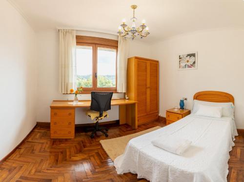 a bedroom with a bed and a desk at Lar de Carmen in Redondela
