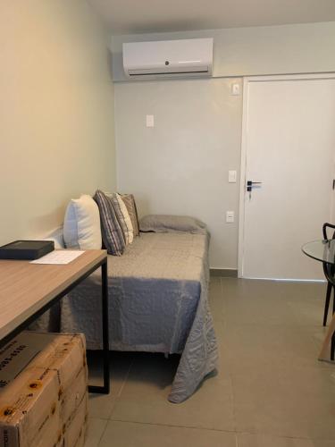 een kamer met een bed, een tafel en een deur bij Apartamento Studio na Beira Mar de Pajuçara - todo reformado in Maceió