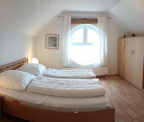 a bedroom with a large bed with a large window at BUPA02208-Ferienwohnung-Passat in Burg auf Fehmarn