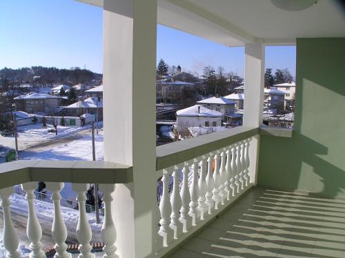 a balcony with a view of a snowy city at Karadzhovy Guest House in Kalofer