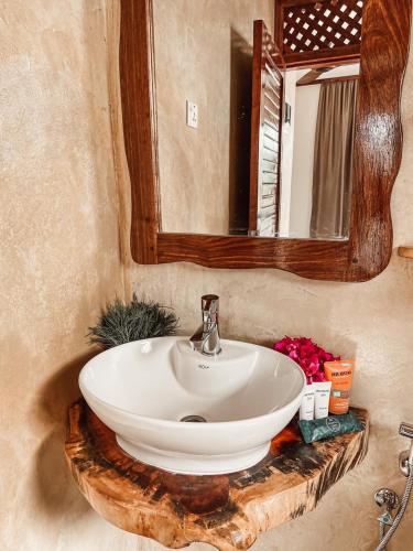 a bathroom with a white sink and a mirror at Paje Blu Boutique Hotel in Paje