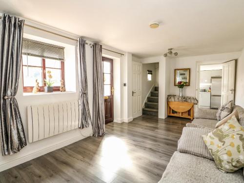 a living room with a couch and a window at Chalk Cottage in Thetford